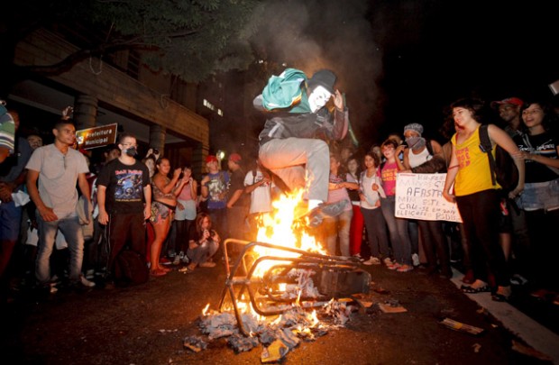 Manifestantes queman un molinete durante una protesta contra la tarifa de ómnibus y los gastos del Mundial. Fotografía: Lincon Zarbietti /O Tempo/Folhapress.